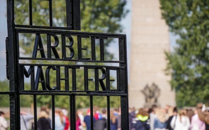 Students passed through the gate of the concentration camp, which read "work will set you free".