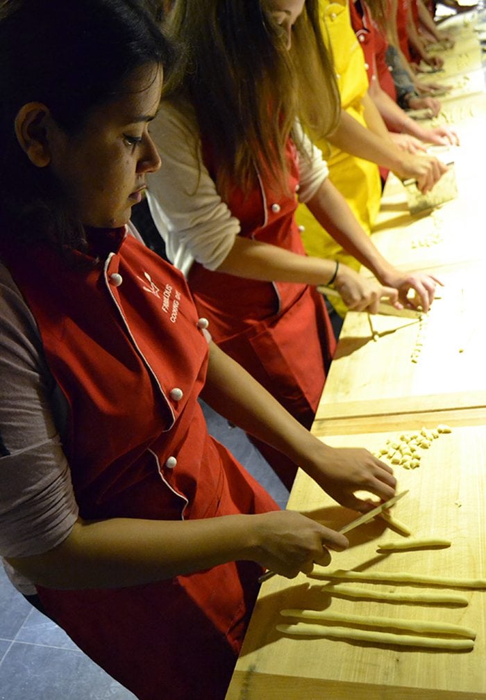 Hafsa Khan from Rutgers University cuts her pasta by hand before it is cooked for the group's lunch.