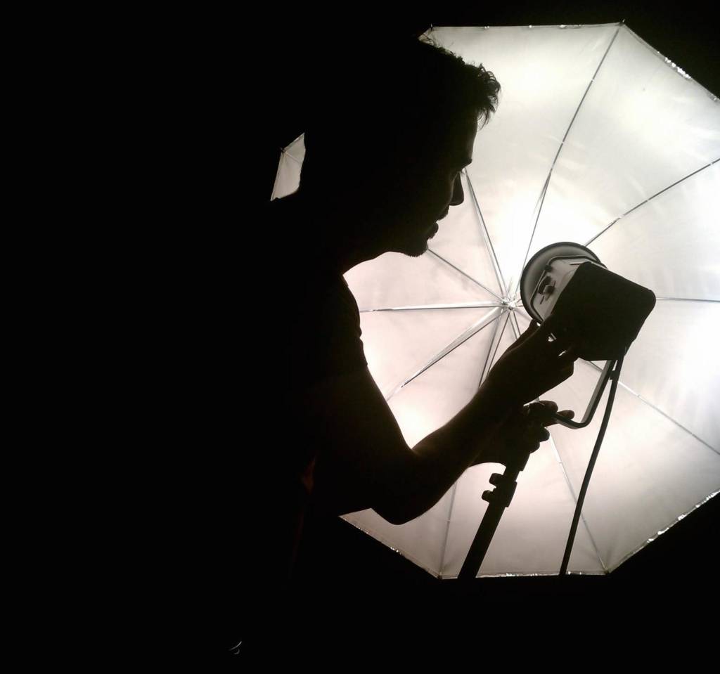 The Fall 2014 documentary photography instructor, Todd Forsgren, sets up a studio umbrella.