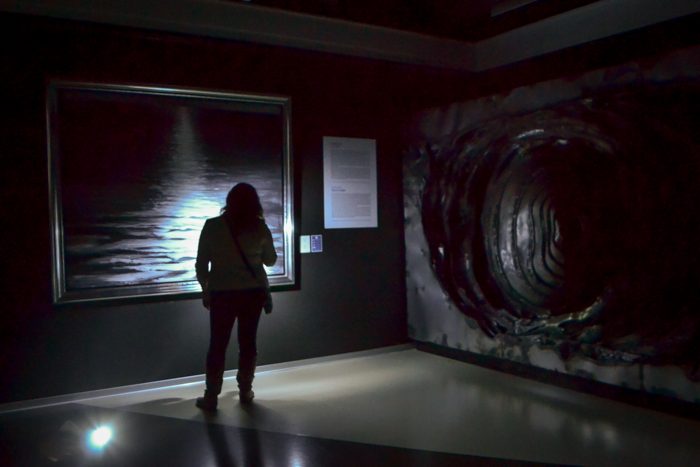 Kelly Bermudez, of Washington State University, tours the Erarta Museum examining each piece with her flashlight.