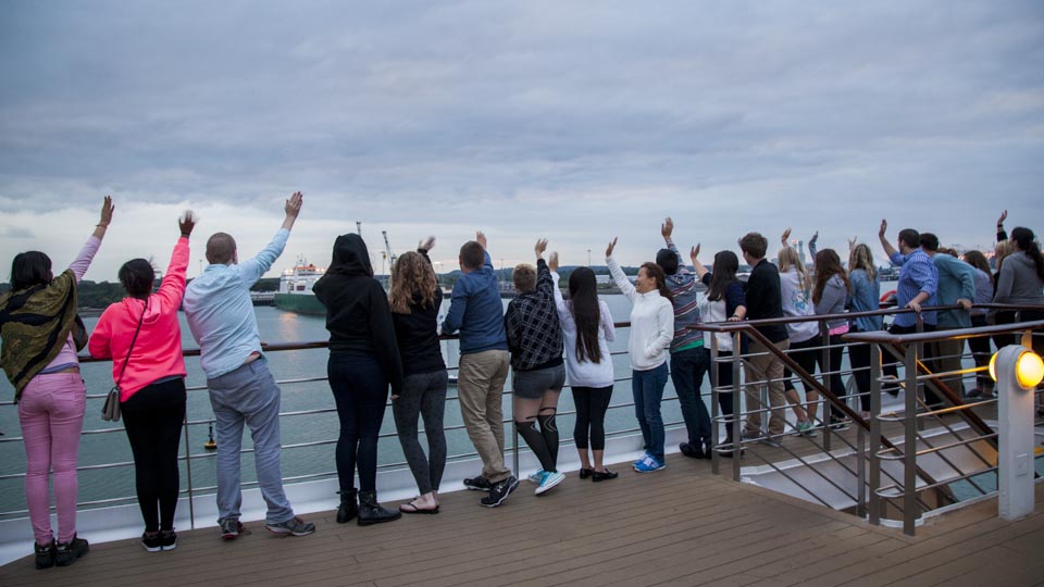 Bon Voyage! Students and Lifelong Learners wave to a passing sailboat as the MV Explorer departs from the pier. 