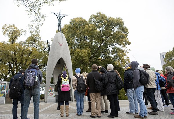 Students gather at the Children's Peace Monument. Sadako Sasaki is holding a paper crane at the top of the sculpture. 