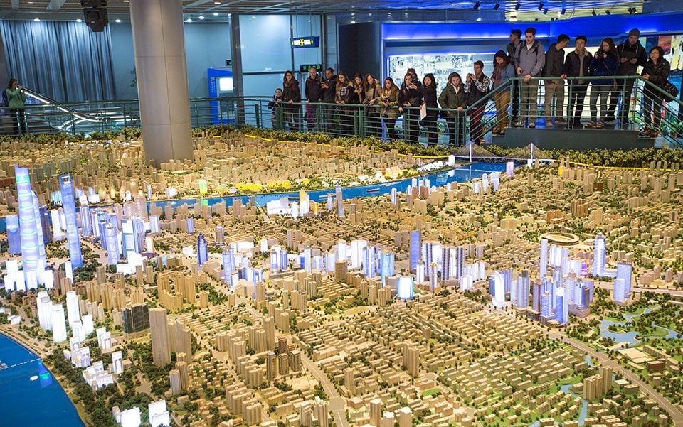 Students view a 1/500 scale model of Shanghai in the Urban Planning Exhibition center. The buildings that are lit represent new or upcoming projects in the city.