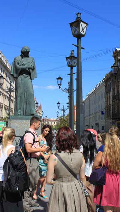 Professor John Casteen and local tour guide Katya Koshevatskaya speak to students underneath a statue of famous Russian writer Nikaloi Gogol. 