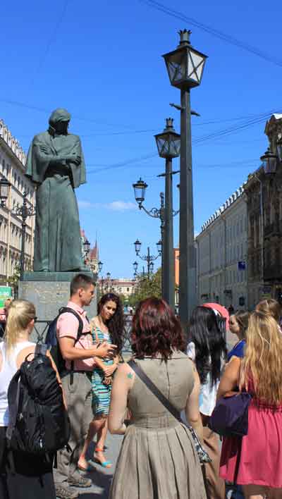 Professor John Casteen and local tour guide Katya Koshevatskaya speak to students underneath a statue of famous Russian writer Nikaloi Gogol.