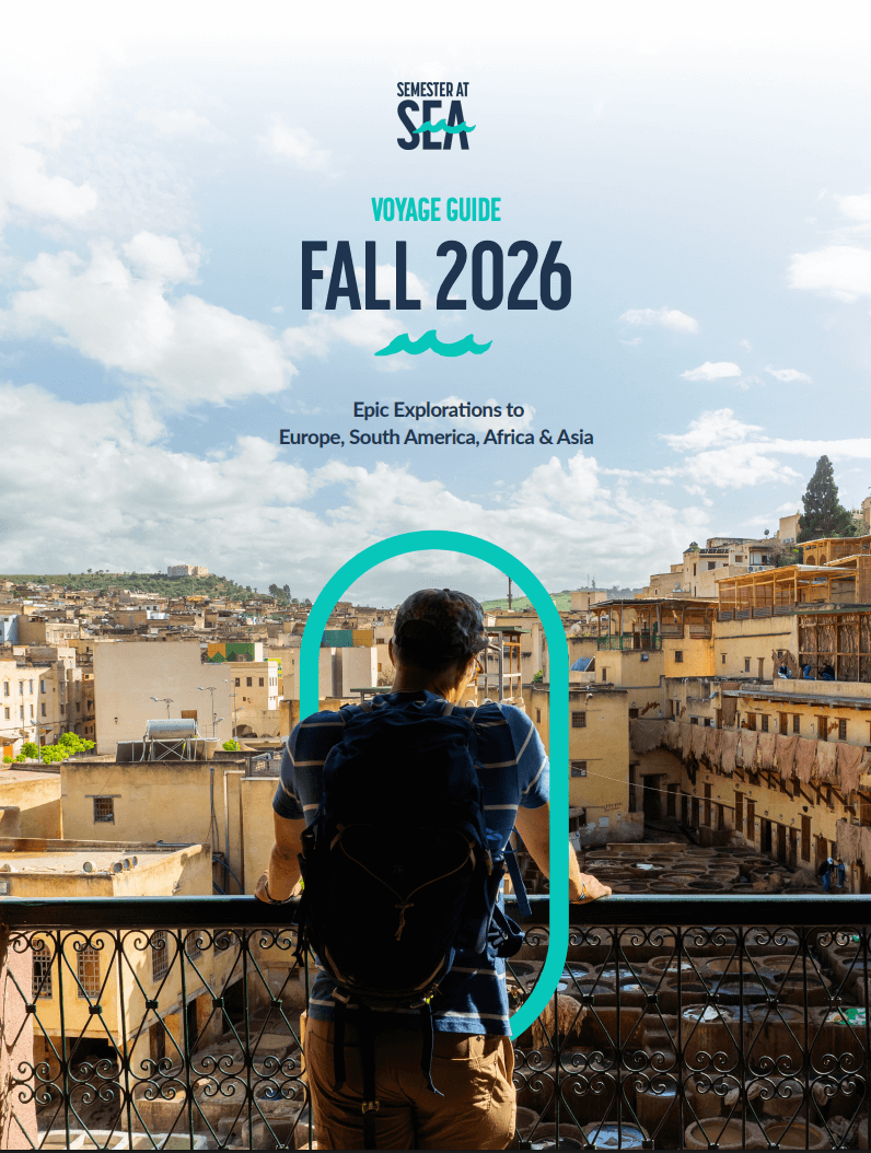 male student looking out at the city from a balcony